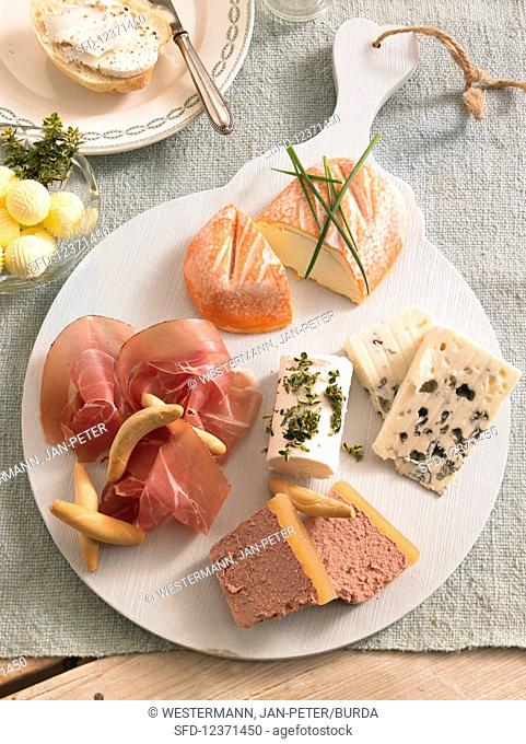 Cheese platter with raw ham and butter balls for brunch