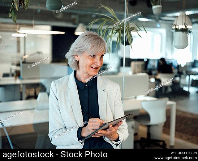 Senior businesswoman using tablet PC at office