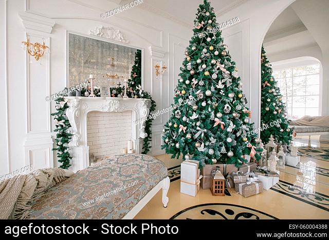 Christmas morning. classic apartments with a white fireplace, decorated Christmas tree, bright sofa, large windows