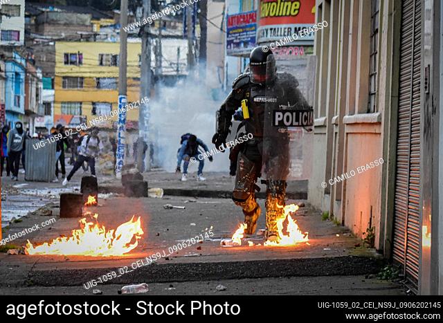 Colombia's riot police officers avoid fires caused during clashes from molotov bombs as demonstrations escalate to unrest and clashes between demonstrators and...