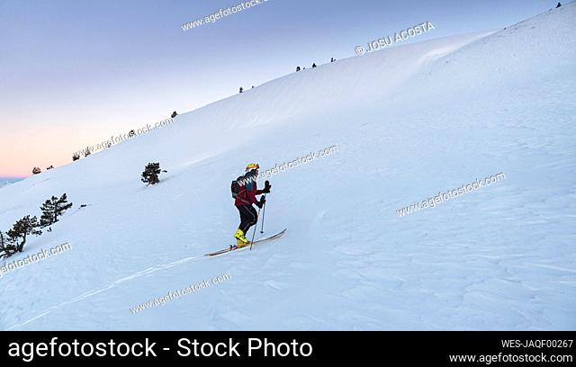 Mature man mountain climbing at Pyrenees mountain during winter