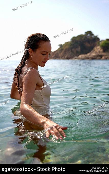 Woman in swimsuit at sea on sunny day