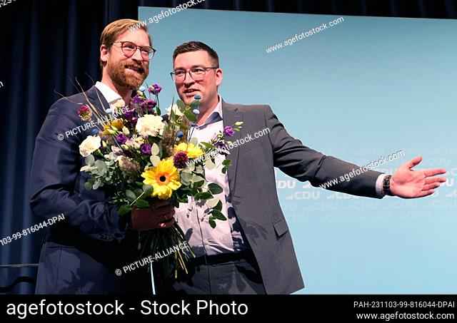 03 November 2023, Mecklenburg-Western Pomerania, Rostock: Jascha Dopp (l) receives a bouquet of flowers from Robert Liskow (CDU)