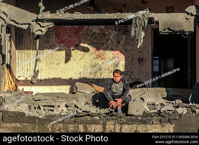 15 December 2023, Palestinian Territories, Rafah: A Palestinian child sits between debris after an Israeli air strike on a house belonging to the Al-Arja family...