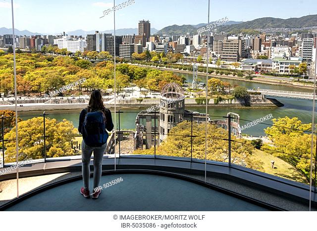 Woman looking from observation platform of Hiroshima Orizuru Tower, panoramic view over the city with atomic bomb dome, Atomic Bomb Dome