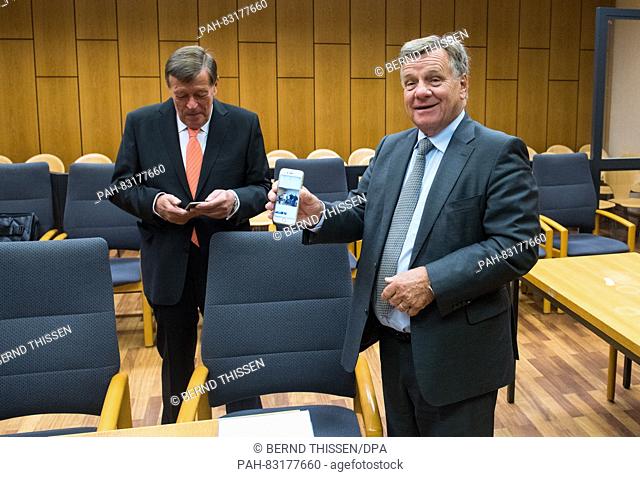 Former manager of Deutsche Bahn, Hartmut Mehdorn (r), shows waiting journalists a photo on his smartphone, which he had taken of the photographers that had...