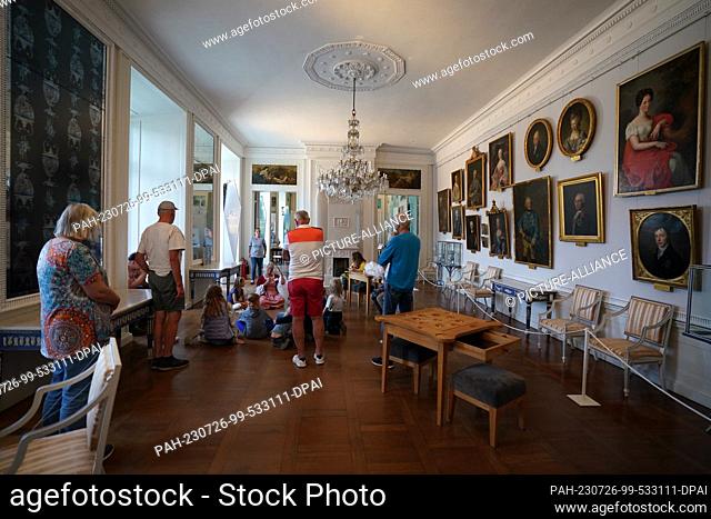 25 July 2023, Schleswig-Holstein, Eutin: Museum guide Monika Seeger-Schreiber (M) speaks during the tour ""Of Powder, Pasties and Silk Wallpapers"" in the...