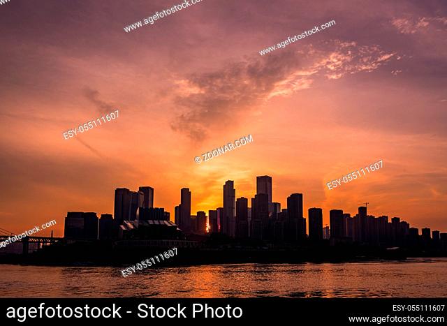 The silhouettes of buildings surrounded by the sea under the sunlight during the sunset in Chongqing, China
