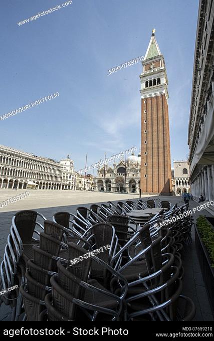 Stacked chairs of closed bars in Piazza San Marco on the day of its patron, during the lockdown due to the Coronavirus pandemic (Covid-19)