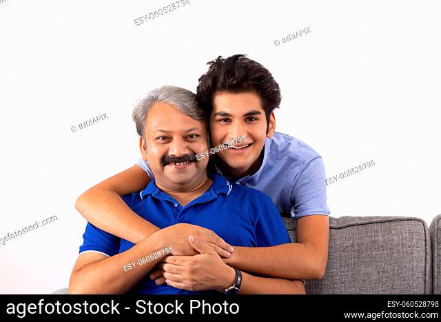 Indian father and son posing together with smiling face in front of camera