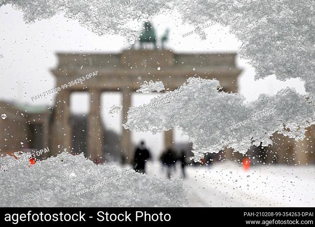 08 February 2021, Berlin: Snow crystals lie on a car window on Pariser Platz in front of the Brandenburg Gate in driving snow and temperatures around minus 10...