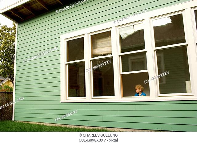 Young boy looking out of window