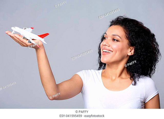 Closeup portrait of happy beautiful woman launching airplane model
