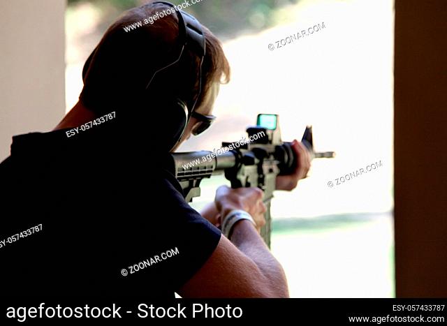 Military man shoots targets with a machine gun