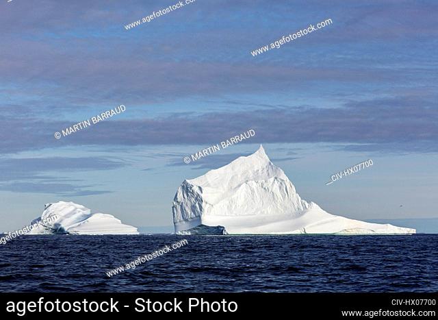 Majestic iceberg formations on sunny blue Atlantic Ocean Greenland