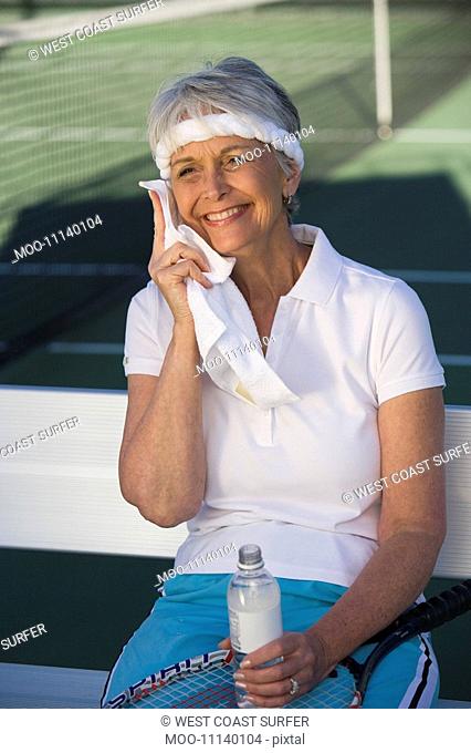 Female tennis player toweling face