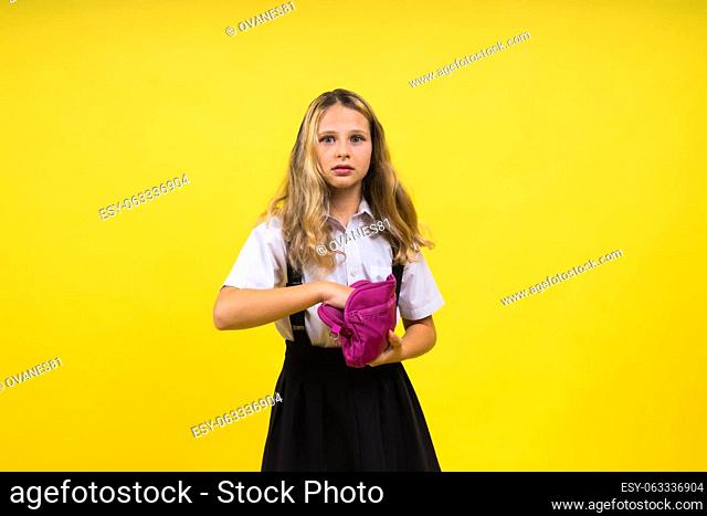 Happy schoolgirl with colored pencils and pencil case in hand