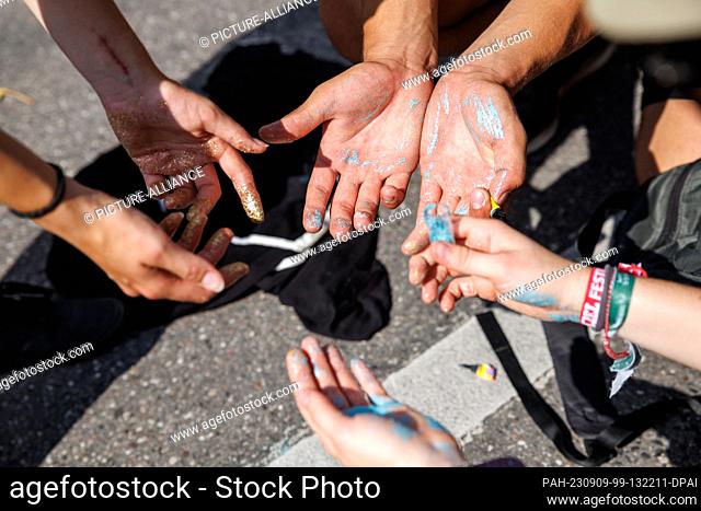 09 September 2023, Bavaria, Munich: Activists dye their fingers with colorful glitter during a protest action by the ""No Future for IAA"" alliance as part of...