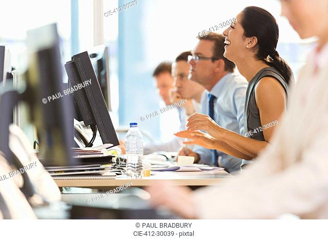 Laughing businesswoman working at computer in office