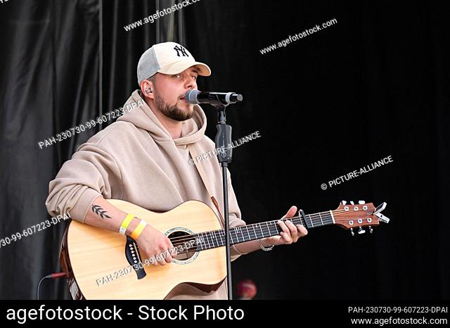 SYMBOL - 29 July 2023, Baden-Württemberg, Mannheim: Musician Luca Noel stands on stage with his guitar during a concert in the courtyard of honor of the baroque...