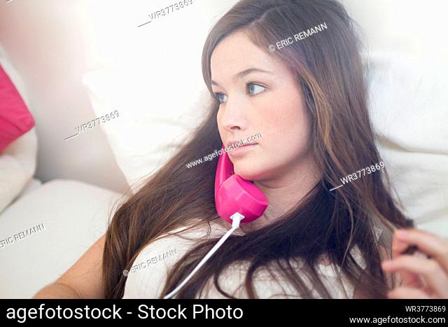 Young woman using phone in bed