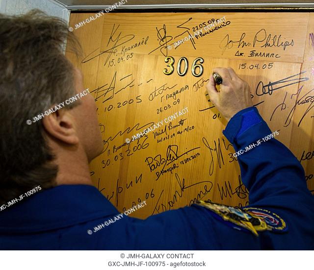 Expedition 31 Soyuz Commander Gennady Padalka continues the traditional of signing one of the doors at the Cosmonaut Hotel on May 15, 2012 in Baikonur