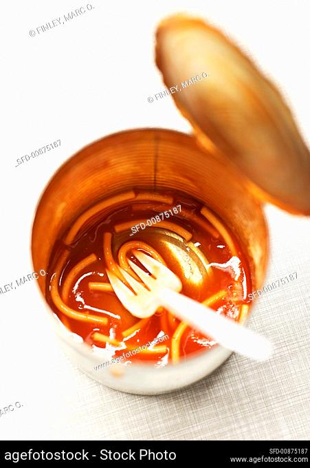 Tin with remains of spaghetti in tomato sauce