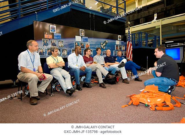 United Space Alliance (USA) crew escape instructor Lynn Coldiron (right) briefs the STS-122 crewmembers during an emergency egress training session in the Space...