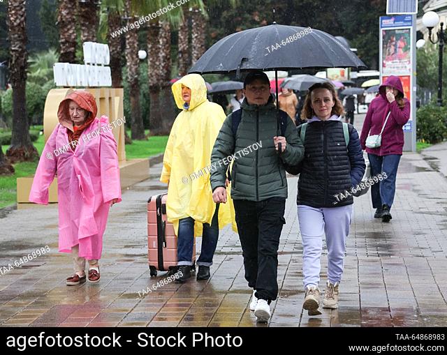 RUSSIA, SOCHI - NOVEMBER 16, 2023: People take shelter under an umbrella during the rain. Dmitry Feoktistov/TASS