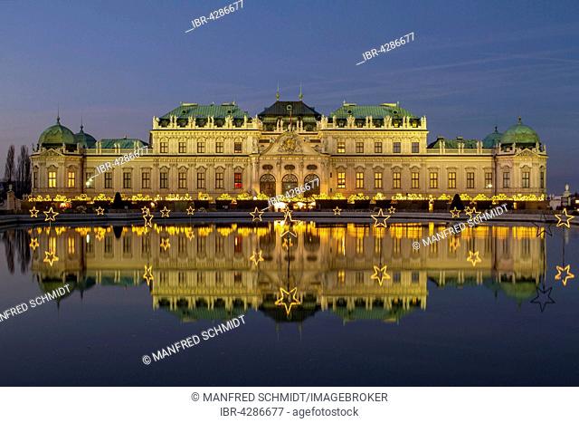 Christmas lights with Christmas Market in front of Belvedere Palace, reflection in the lake, Vienna, Austria