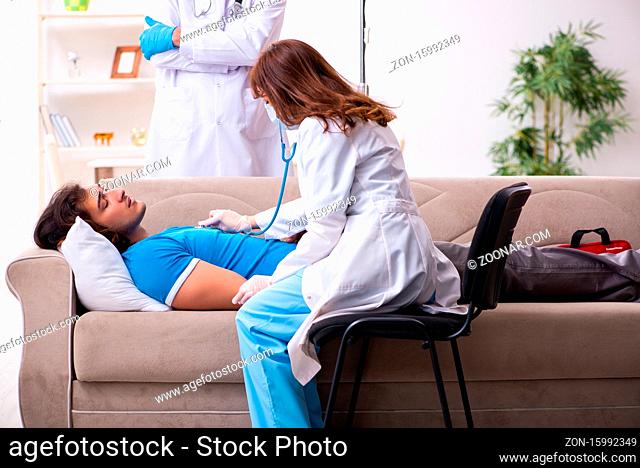 Two doctors visiting sick man at home