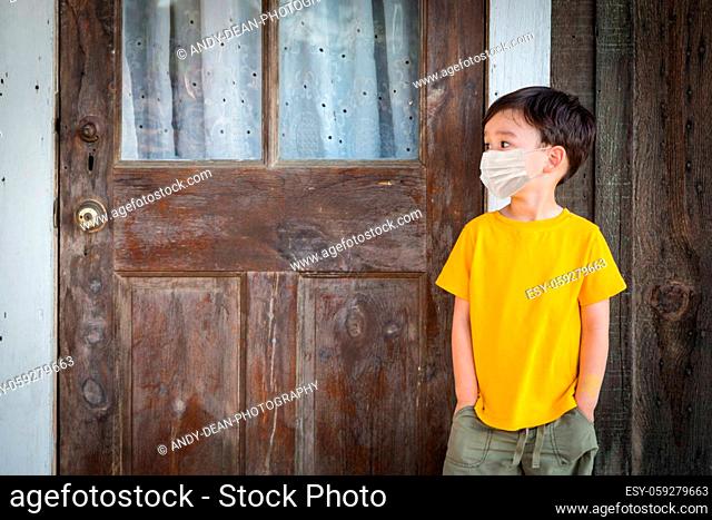 Young Mixed Race Chinese and Caucasian Boy Playing Alone Wearing Medical Face Mask Outside