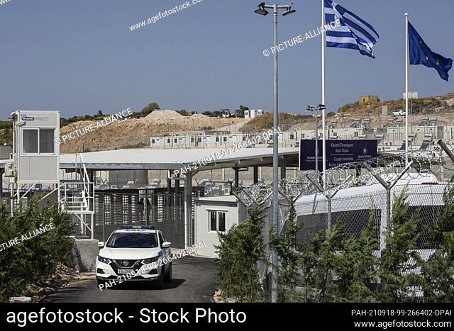 18 September 2021, Greece, Samos: A police car drives past the main gate of the newly established refugee camp on the island of Samos