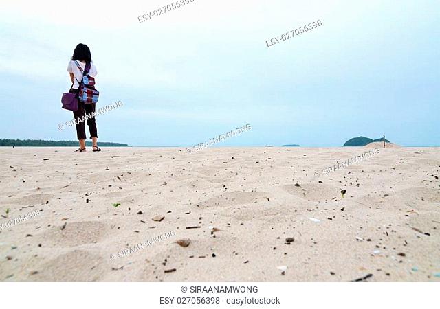 Lonely young woman on the beach, warm's eye view