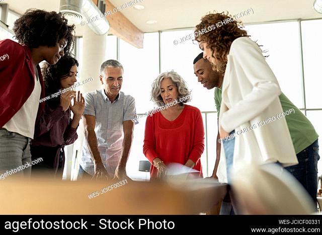 Senior businesswoman discussing strategy with colleagues in meeting at office