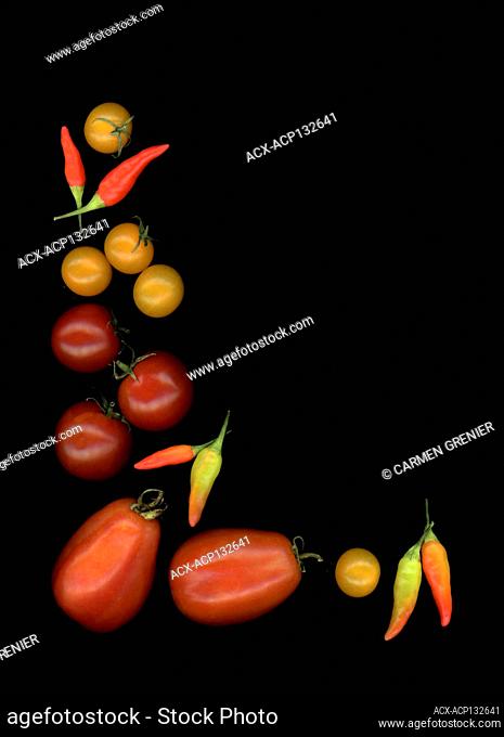 Italian tomatoes, yellow and red cherry tomatoes and chili peppers on a dark background