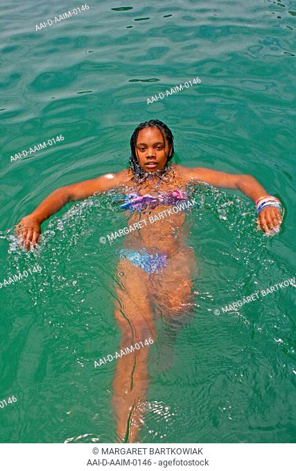 School girl floating in swimming pool, St Mark's School, Mbabane, Hhohho, Kingdom of Swaziland