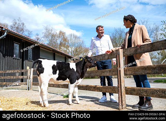 24 April 2021, Lower Saxony, Bockum: Wolfgang Glauser (l), facility manager of SOS-Hof Bockum, and Leonie Laryea, an employee, talk next to a calf