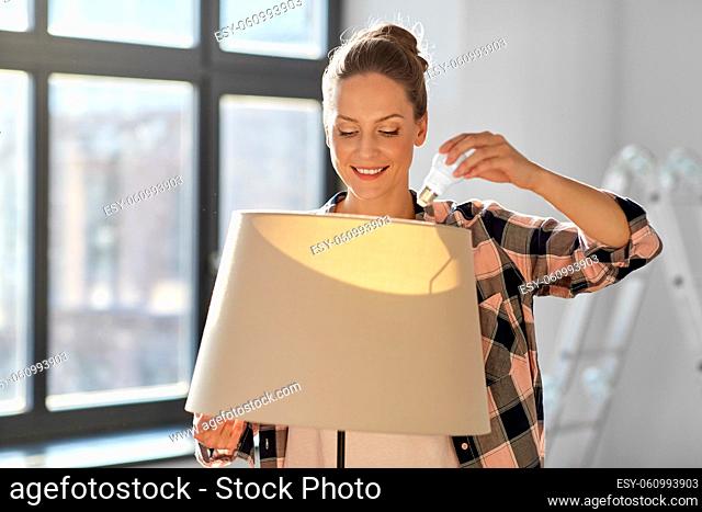woman changing light bulb at new home