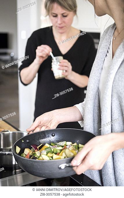 Friends cooking vegetarian food together
