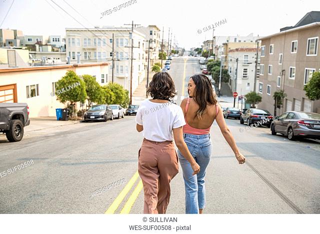 Two young women walking down the street