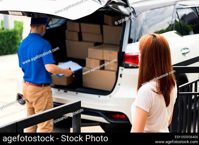 Asian young delivery man courier shopping online give parcel post box he protective face mask and service woman customer receiving boxed at front home door