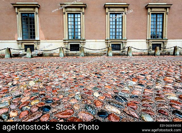 Wet Cobblestone and King Palace Facade in Gamla Stan (Old Town) of Stockholm, Sweden