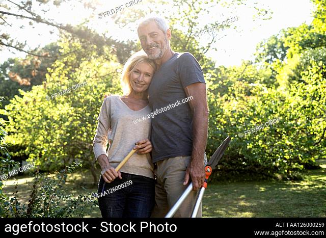 Portrait of mature couple standing in backyard