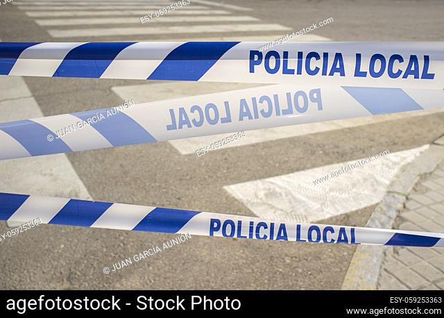 Municipal Police tape close to crosswalk. Banner letters in spanish languaje