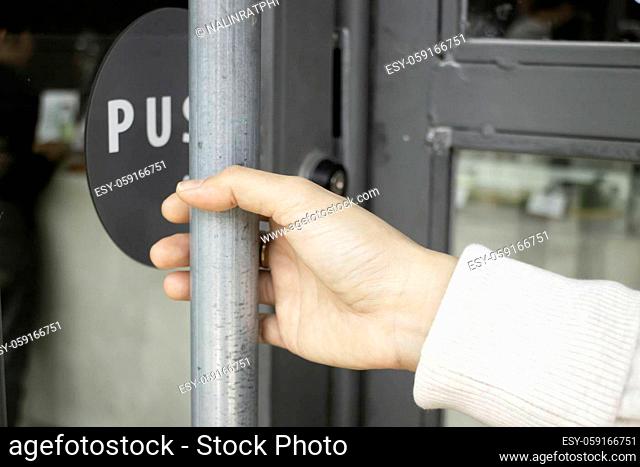 Hand on handle door for open to entering restaurant, stock photo