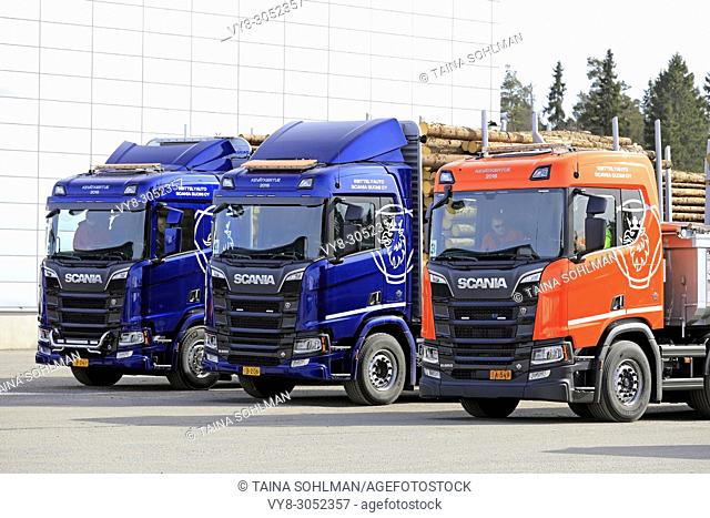 Three new Scania trucks, blue R730 and R650 for wood transport and orange R650 for construction during Scania Tour Turku 2018 in Lieto, Finland - April 12, 2018