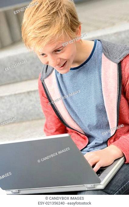 Surprised teenage student using laptop