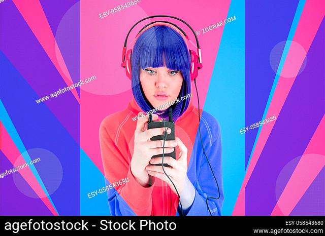 Girl with headphone listens pleasurable music in her smartphone. Art collage with funky beautiful young woman with blue hair on multicolor background