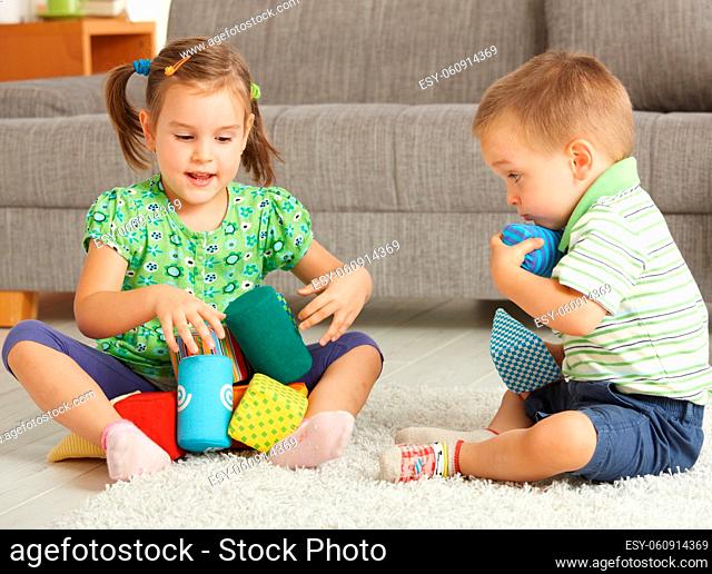 3-4 years old children playing together on the floor at home